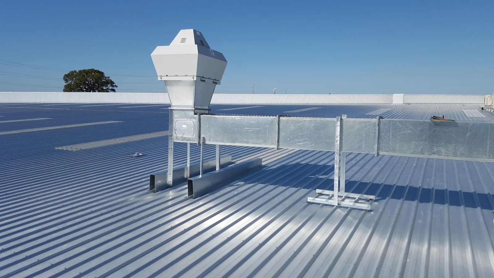 Ribbed metal roof panels with rooftop ductwork